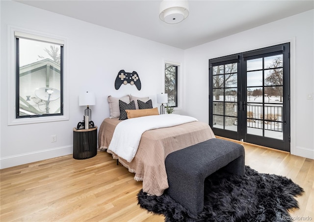 bedroom with light hardwood / wood-style floors, access to exterior, and french doors