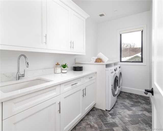 washroom featuring cabinets, sink, and washing machine and dryer