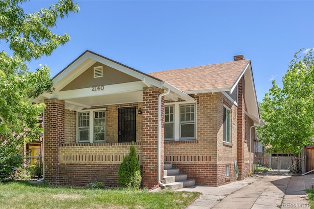 2140 S Washington St, Denver, CO 80210 - view of front of house featuring brick siding, a chimney, a shingled roof, and covered porch
