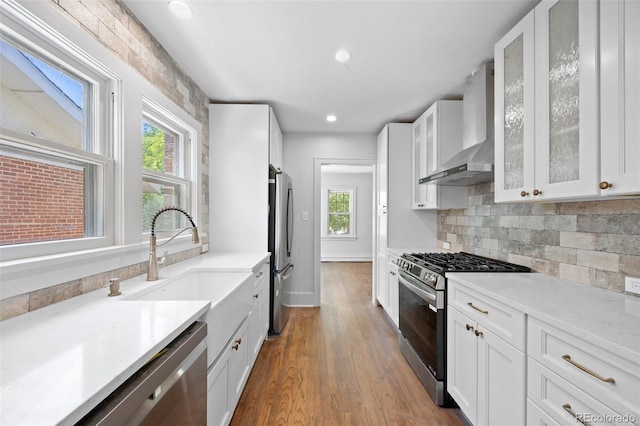 2140 S Washington St, Denver, CO 80210 - kitchen featuring appliances with stainless steel finishes, wall chimney range hood, white cabinets, light countertops, and recessed lighting