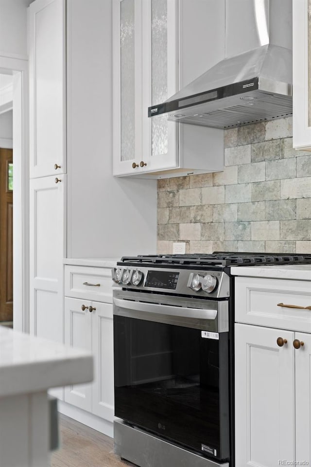 2140 S Washington St, Denver, CO 80210 - kitchen with wall chimney range hood, stainless steel gas range oven, and white cabinets