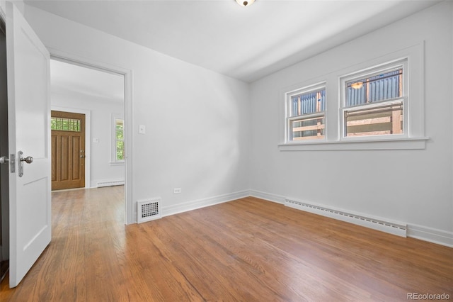 2140 S Washington St, Denver, CO 80210 - unfurnished room with a baseboard radiator, wood finished floors, and baseboards