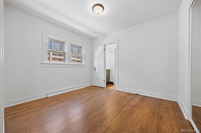 2140 S Washington St, Denver, CO 80210 - unfurnished bedroom featuring a baseboard radiator, wood finished floors, baseboards, and a closet