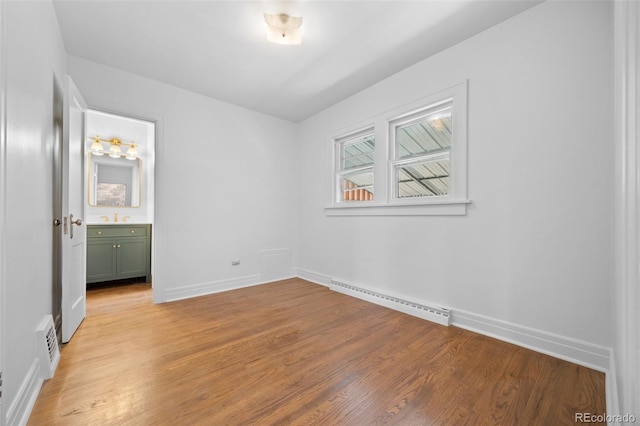 2140 S Washington St, Denver, CO 80210 - unfurnished bedroom with a baseboard radiator, light wood finished floors, baseboards, and a sink