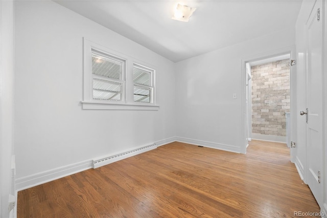 2140 S Washington St, Denver, CO 80210 - spare room featuring baseboard heating, baseboards, and light wood-style floors