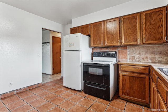 4940-42 W 9th Ave W, Denver, CO 80204 - kitchen featuring freestanding refrigerator, range with electric cooktop, brown cabinetry, tile countertops, and tasteful backsplash