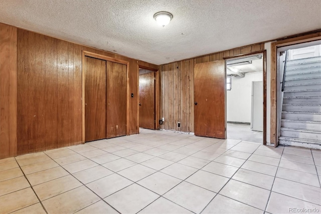 4940-42 W 9th Ave W, Denver, CO 80204 - unfurnished bedroom with wooden walls, freestanding refrigerator, a closet, and a textured ceiling