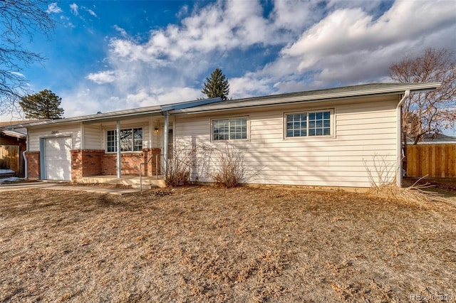 single story home featuring covered porch, a front yard, and a garage