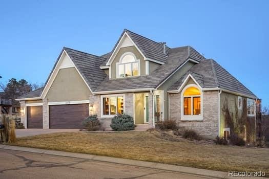 view of front facade with stone siding, driveway, and an attached garage