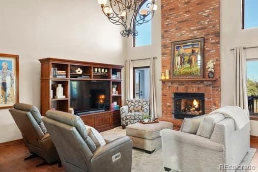 living area with plenty of natural light, a fireplace, and a high ceiling