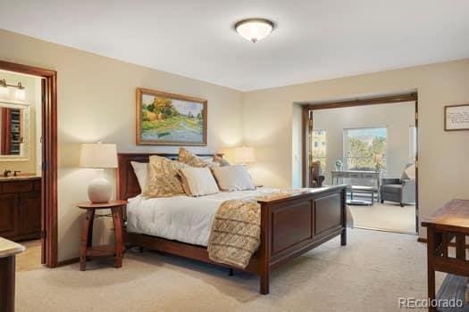 bedroom featuring light carpet and ensuite bath