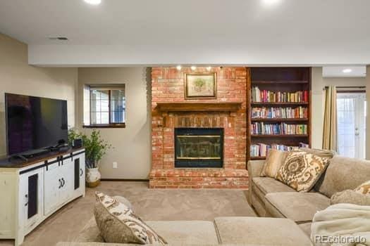 living area featuring carpet floors, a fireplace, a wealth of natural light, and baseboards