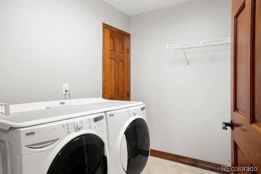 laundry room with laundry area, baseboards, and separate washer and dryer