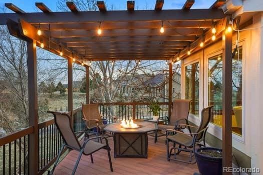 wooden deck with an outdoor fire pit and a pergola