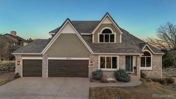 view of front of house with driveway, brick siding, and an attached garage