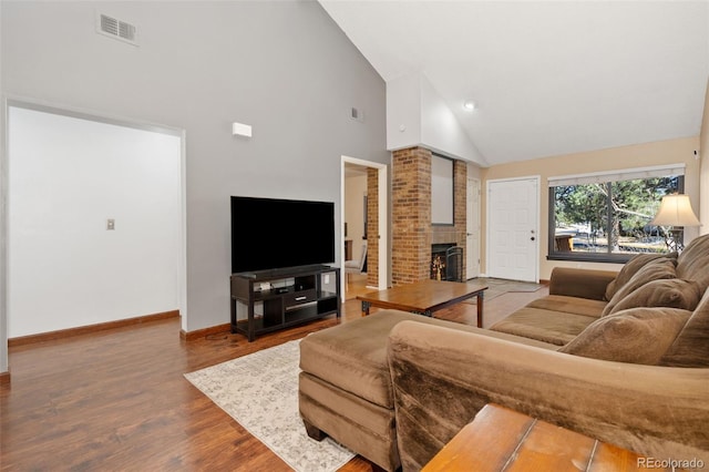 living area with visible vents, high vaulted ceiling, baseboards, and wood finished floors