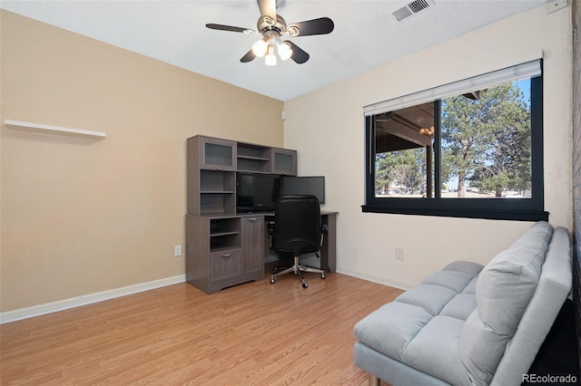 office space featuring visible vents, baseboards, ceiling fan, and light wood finished floors