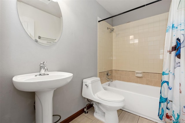 bathroom with baseboards, toilet, and shower / bath combo