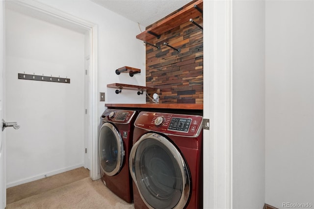 washroom featuring carpet, baseboards, laundry area, separate washer and dryer, and a textured ceiling