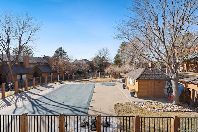 community pool featuring a patio area, fence, and a residential view