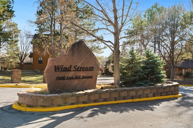 community / neighborhood sign featuring fence