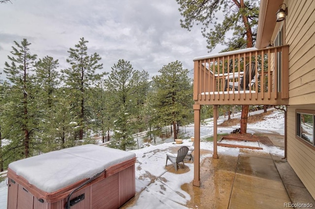yard layered in snow featuring a hot tub and a patio