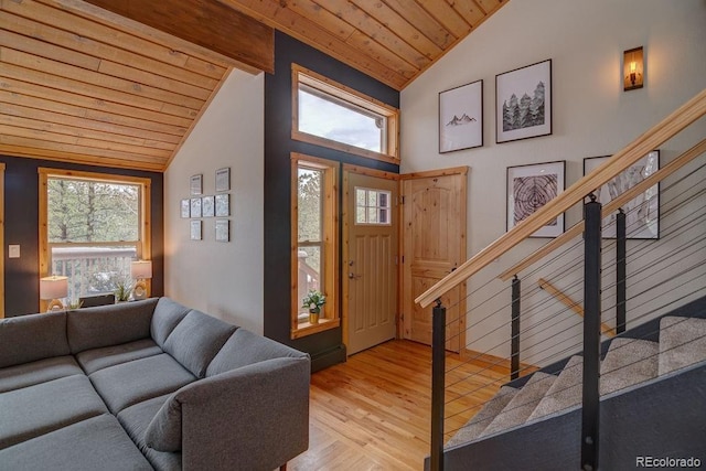 foyer entrance with wood ceiling, wood finished floors, and high vaulted ceiling