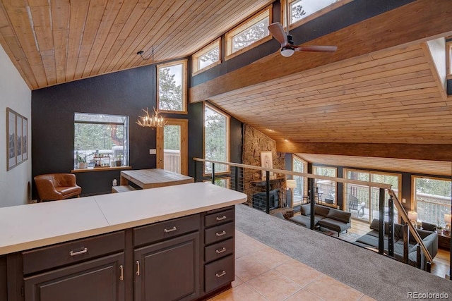 kitchen featuring wooden ceiling, light tile patterned flooring, open floor plan, a ceiling fan, and a chandelier
