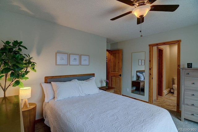 carpeted bedroom with ensuite bathroom, a textured ceiling, and ceiling fan