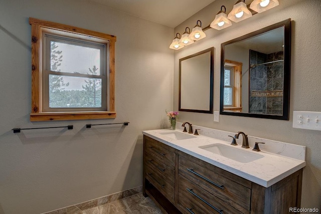 full bathroom with plenty of natural light, double vanity, and baseboards