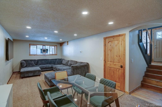 living area with a textured ceiling, recessed lighting, arched walkways, healthy amount of natural light, and stairway