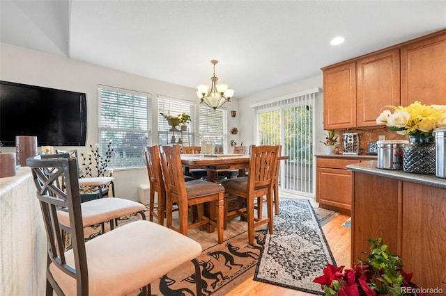 dining space featuring light hardwood / wood-style flooring and an inviting chandelier