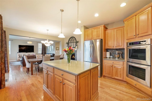 10705 Pinewalk Way, Highlands Ranch, CO 80130 - kitchen with stainless steel appliances, a chandelier, light wood-style floors, light countertops, and tasteful backsplash