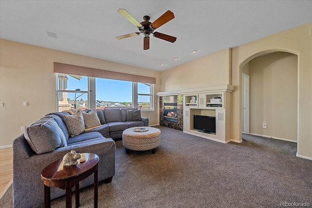 23425 E Otero Dr, Aurora, CO 80016 - carpeted living area featuring arched walkways, a ceiling fan, and a tile fireplace