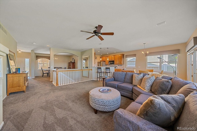 23425 E Otero Dr, Aurora, CO 80016 - living room with a ceiling fan, a chandelier, carpet flooring, and arched walkways