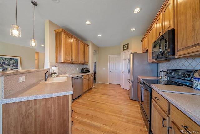 23425 E Otero Dr, Aurora, CO 80016 - kitchen with black appliances, recessed lighting, light wood finished floors, tasteful backsplash, and brown cabinets