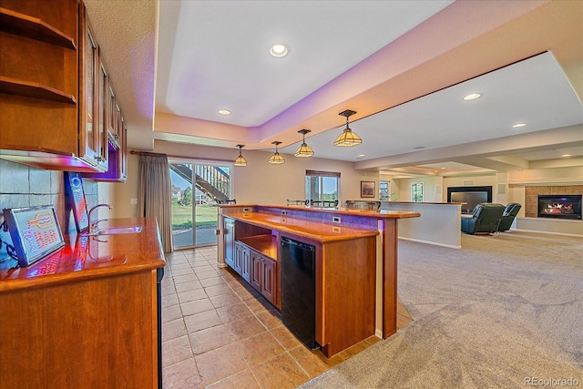 23425 E Otero Dr, Aurora, CO 80016 - kitchen featuring a glass covered fireplace, brown cabinetry, a kitchen island, dishwasher, and pendant lighting