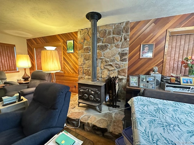 33691 Nova Rd, Pine, CO 80470 - living area featuring a wood stove, wood walls, and a textured ceiling