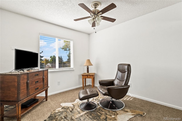 sitting room with ceiling fan, light colored carpet, and a textured ceiling