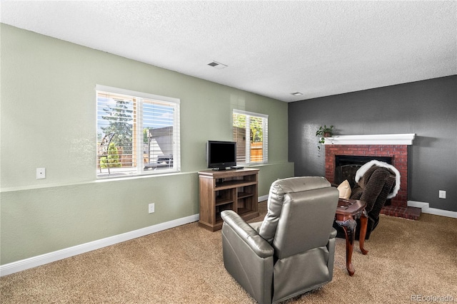 carpeted living room featuring a brick fireplace and a textured ceiling