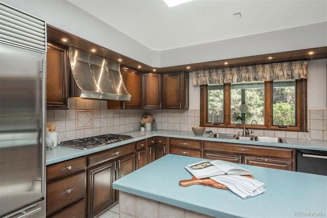 kitchen featuring a sink, light countertops, stainless steel appliances, range hood, and backsplash