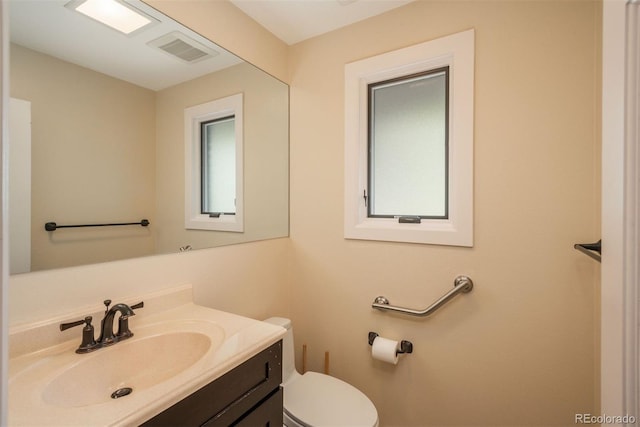 bathroom featuring visible vents, toilet, and vanity