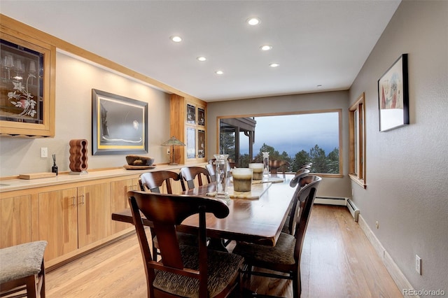 dining room with baseboard heating and light wood-type flooring