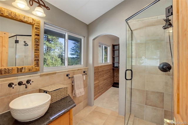 bathroom featuring lofted ceiling, tile patterned flooring, an enclosed shower, and tile walls