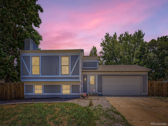 1956 Cathay St, Aurora, CO 80011 - view of front of home with an attached garage, driveway, and a chimney