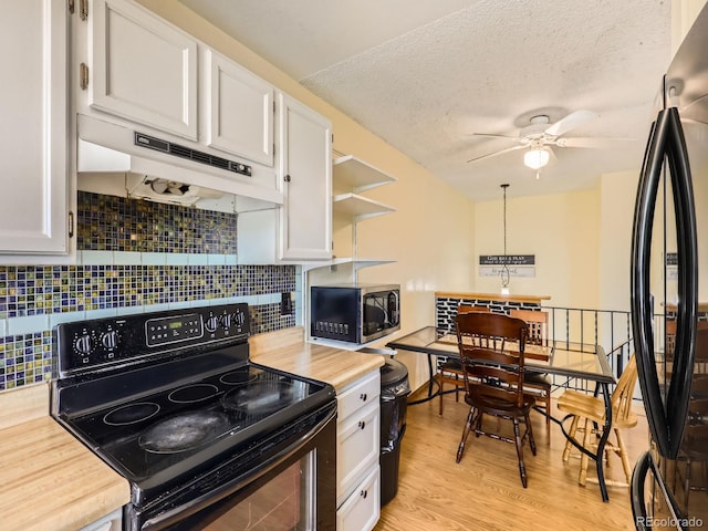 1956 Cathay St, Aurora, CO 80011 - kitchen with black appliances, under cabinet range hood, white cabinets, tasteful backsplash, and light wood finished floors