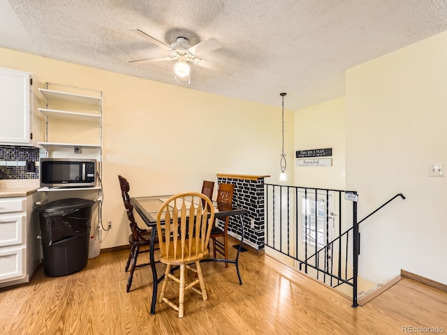1956 Cathay St, Aurora, CO 80011 - dining space with light wood finished floors, a textured ceiling, and a ceiling fan