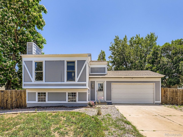 1956 Cathay St, Aurora, CO 80011 - view of front of house with a garage, driveway, a chimney, and stucco siding