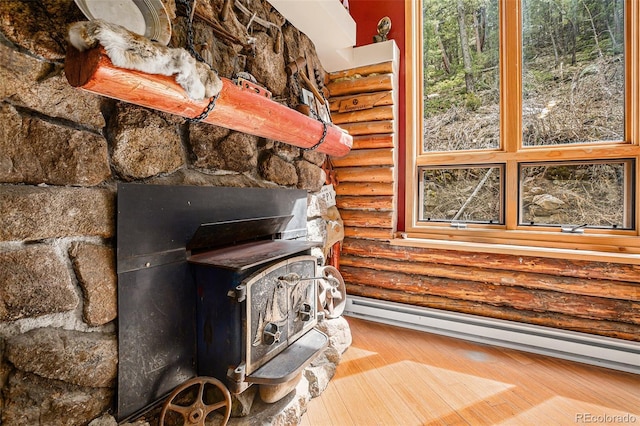 details featuring rustic walls, baseboard heating, and a wood stove