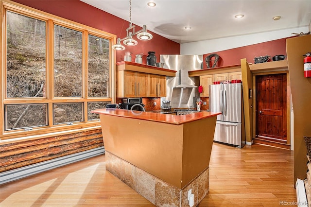 kitchen with decorative light fixtures, baseboard heating, stainless steel fridge, and light hardwood / wood-style flooring